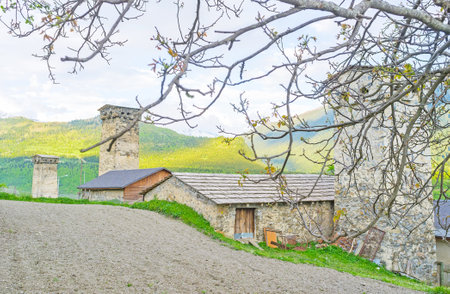 The plowed meadow next to the old farms with medieval Svan towers, Mestia, Upper Svaneti, Georgia.のeditorial素材