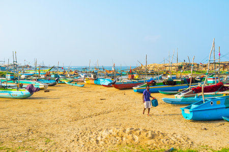 HIKKADUWA, SRI LANKA - DECEMBER 5, 2016: The traditional catamaran-boats, painted in different colors, on the sand at the fishing harbor, on December 5 in Hikkaduwa.のeditorial素材