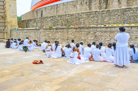 ANURADHAPURA, SRI LANKA - NOVEMBER 26, 2016: The worshipers make the common prayer, sitting on the floor at Ruwanwelisaya Stupa,  on November 26 in Anuradhapura.のeditorial素材