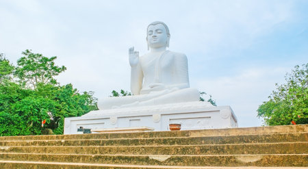The Buddha Statue in Abhaya Mudra hand pose, symbolizing safety and no fear, located at the top of Mahinda's Hill in Mihintale Temple, Sri Lanka.のeditorial素材