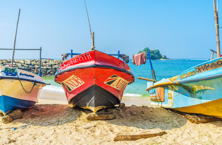 MIDIGAMA, SRI LANKA - DECEMBER 3, 2016: The comfortable beach with a view on the fishing boats and Devil's Island on the background, on December 3 in Midigama.のeditorial素材