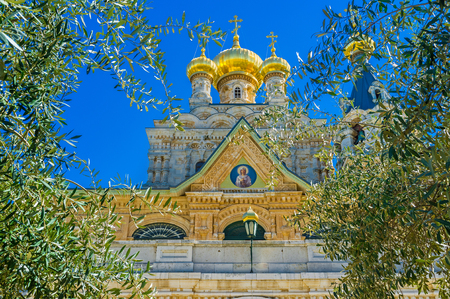 The small golden domes of the Russian Orthodox Church of Mary Magdalene through the lush greenery of its garden, Jerusalem, Israel.の写真素材