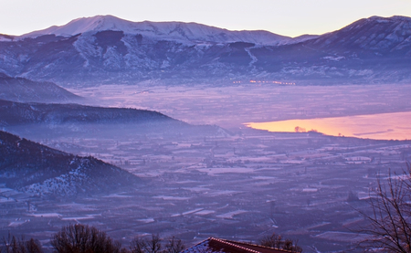 The purple valley of Kastoria, surrounded by snowy mountains and covered with light haze, Greece.の写真素材