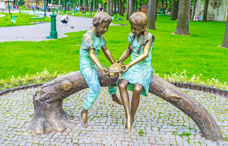 The bronze sculpture of children, playing with a turtle, Gorky Park of Kharkov, Ukraine.の写真素材