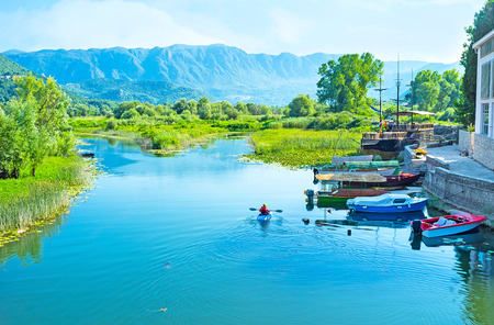 The bright blue river flows to Skadar Lake across the Virpazar settlement, Montenegro.の写真素材