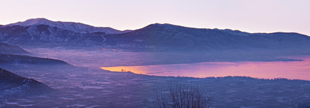 The misty winter morning in Kastoria, the Orestiada lake reflects the purple sky, Greece.の写真素材