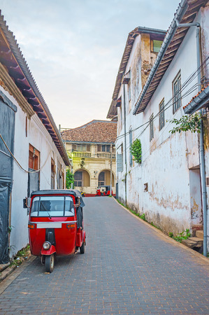 The narrow street of Galle Fort with parked red tuk tuk, Sri Lanka.の写真素材