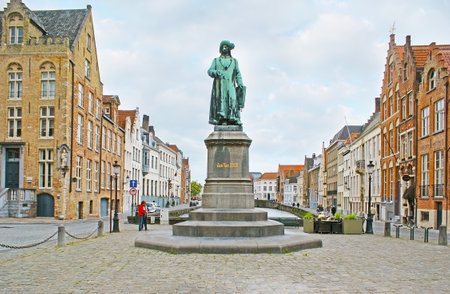 BRUGES, BELGIUM - MAY 26, 2011: The monument to the famous painter Jan van Eyck at Jan van Eyckplein, surrounded by medieval brick stepped gables, separated by Spiegelrei canal, on May 26 in Bruges.のeditorial素材