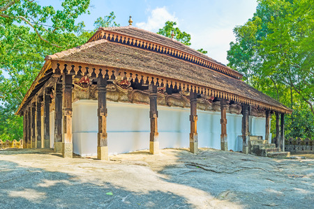 Padeniya Raja Maha Viharaya Temple, located on the top of the rock and decorated with carved wooden pillars and unique frieze of lions, stretching around the building, Sri Lanka.の写真素材