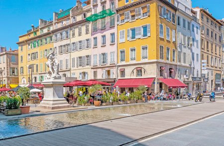 MARSEILLE, FRANCE - MAY 4, 2013: Milon de Crotone statue surrounded by fountain, green plants in pots, colorful houses and cozy outdoor cafes of Estienne d'Orves Square, on May 4 in Marseille.のeditorial素材