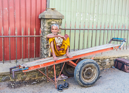 COLOMBO, SRI LANKA - DECEMBER 6, 2016: The portrait of the senior smiling porter, that sits on his...