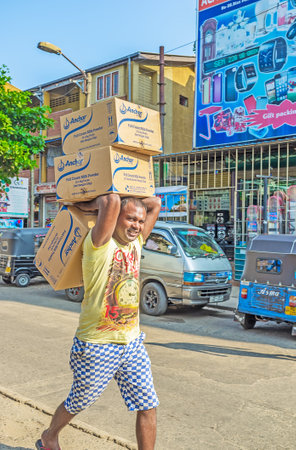 COLOMBO, SRI LANKA - DECEMBER 6, 2016: The porter in Pettah carries the boxes to the market stall, on December 6 in Colombo.のeditorial素材