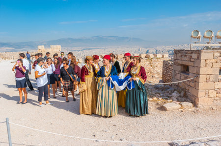 ATHENS, GREECE - OCTOBER 12, 2013: The traditionaly dressed women with National Flag of Greece on archaeological site of Acropolis, on October 12 in Athensのeditorial素材