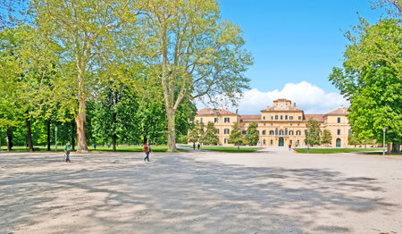 PARMA, ITALY - APRIL 24, 2012: The walk in shade of trees of Ducal Park with the view on Ducal Palace, on April 24 in Parma.のeditorial素材