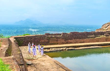 SIGIRIYA, SRI LANKA - NOVEMBER 27, 2016: The group of Sri Lankan schoolboys at the bank of the cistern in Sigiriya Fortress, on November 27 in Sigiriya.のeditorial素材