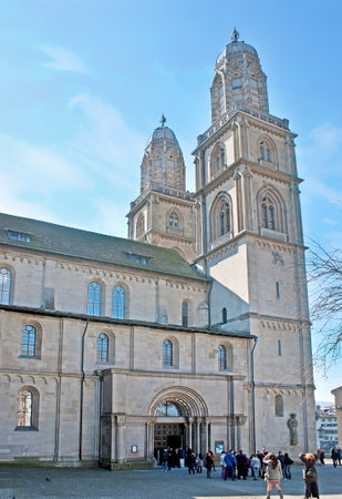 ZURICH, SWITZERLAND - MARCH 20, 2011: The tall belfries of Grossmunster Kirche (Great Minster) and the entrance to the church from Zwingliplatz square, on March 20 in Zurich.のeditorial素材