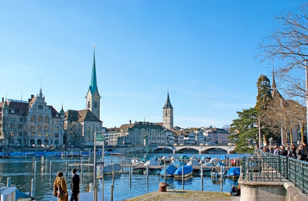 ZURICH, SWITZERLAND - MARCH 20, 2011: The shipyards along the Limmat river quay with the view on tall spires of Fraumunster Kirche and St Peter Kirche, on March 20 in Zurich.のeditorial素材