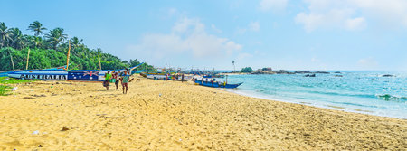 HIKKADUWA, SRI LANKA - DECEMBER 4, 2016: Panorama of Dodanduwa harbor, the fishing crew walks along the shore with fresh catch, on December 4 in Hikkaduwa.のeditorial素材