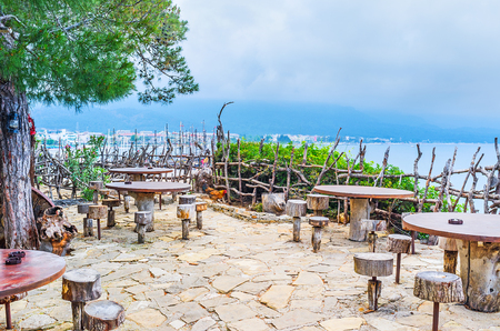 The hilltop of Yoruk park is occupied with open air cafe with wooden tables and chairs, located at the edge of a hill, Kemer, Turkey.の写真素材