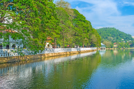 KANDY, SRI LANKA - NOVEMBER 28, 2016: The view on embankment of Kandy Lake with white fence, called The Waves Wall, on November 28 in Kandy.のeditorial素材