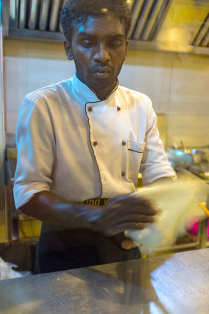 KANDY, SRI LANKA - NOVEMBER 28, 2016: The cook knead the dough for further cooking roti, on November 28 in Kandy.のeditorial素材