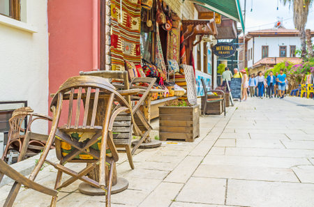 ANTALYA, TURKEY - MAY 6, 2017: The antique rug store in Kaleici district with old wooden table and chairs on the foreground, on May 6 in Antalya.のeditorial素材