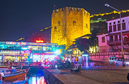 ALANYA, TURKEY - MAY 8, 2017: The walk along the old marina with a view on fish tavern and Kizil Kule - Arsenal tower of the medieval Citadel, on May 8 in Turkey.のeditorial素材