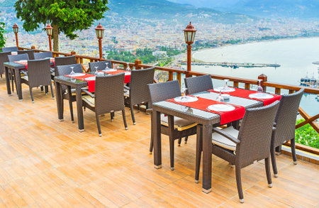 The tables on the cozy summer terrace of luxury restaurant, located on the Castle Hill of Alanya, Turkey.のeditorial素材