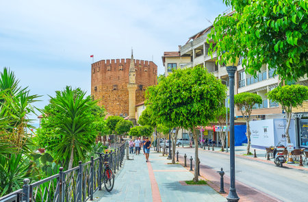 ALANYA, TURKEY - MAY 9, 2017: The narrow street with lush green plants leads to the Haci Kadiroglu Mosque and the Red Tower, on May 9 in Alanya.のeditorial素材