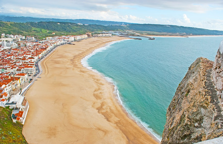 The sand beach of Praia district is seen from the hilltop of Nazare, Costa de Prata (Silver Coast), Portugal.の写真素材