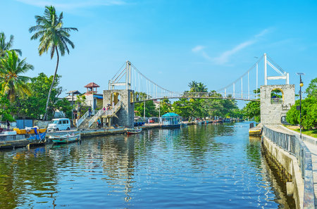 COLOMBO, SRI LANKA - DECEMBER 7, 2016: The bridge above the Hamilton's Canal in Wattala suburb is surrounded by lush greenery of park with the fishing boats, moored at the banks of the canal, on December 7 in Colombo.のeditorial素材