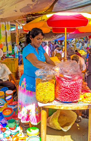 WELLAWAYA, SRI LANKA - DECEMBER 2, 2016: The woman seller in small snack stall offers nuts in spices and sweet nuts in big plastic bags, on December 2 in Wellawayaのeditorial素材