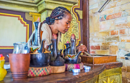 KIEV, UKRAINE - JUNE 4, 2017: The young EthiopianTigrayan girl at work - she roasts coffee beans for the traditional coffee ceremony, on June 4 in Kiev.のeditorial素材