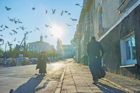 POCHAYIV, UKRAINE - AUGUST 29, 2017: The   monk walk on the street toward to Pochayiv Lavra, on August 29 in Pochayiv.のeditorial素材