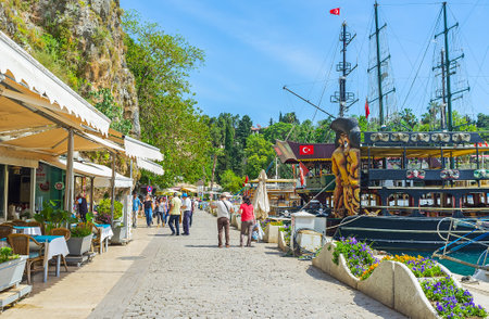 ANTALYA, TURKEY - MAY 12, 2017: The tourists walk along the promenade with pleasue boats, galleons, cafes and bars of old marina, on May 12 in Antalya.のeditorial素材