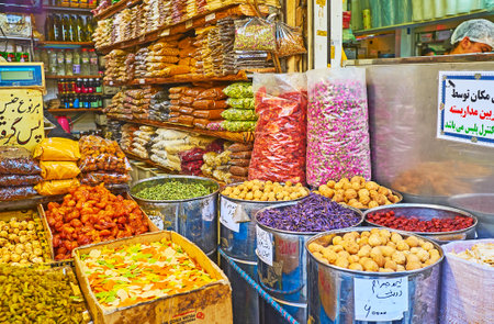 TEHRAN, IRAN - OCTOBER 11, 2017: Traditional Eastern stall with large amount of spices, herbs, dry saffron, roses and fruits in boxes and packets, Grand Bazaar, on October 11 in Tehran, Iran.のeditorial素材