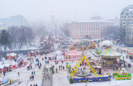 KIEV, UKRAINE - JANUARY 4, 2017: The view from bell tower of St Michael's Cathedral on Amusement Park, Christmas Fair, Market and St Sophia Cathedral under the heavy snowfall, on January 4 in Kiev.のeditorial素材