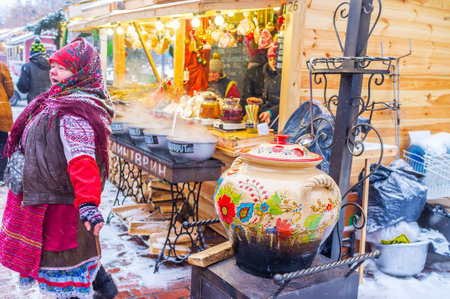 KIEV, UKRAINE - JANUARY 4, 2017: Old woman fairground barker  attracts clients with traditional songs, on January 4 in Kiev.のeditorial素材