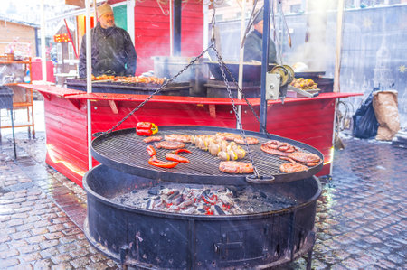 KIEV, UKRAINE - JANUARY 4, 2017: 
The grill at Christmas Market with fragrant sausages, frankfurters, potato on skewers and peppers attracts visitors with delicious smell, on January 4 in Kiev.のeditorial素材
