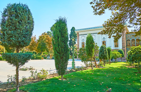 The ornamental Golestan garden with trimmed coniferous trees, juicy green lawn and wide alleys between the edifices, Tehran, Iran.のeditorial素材