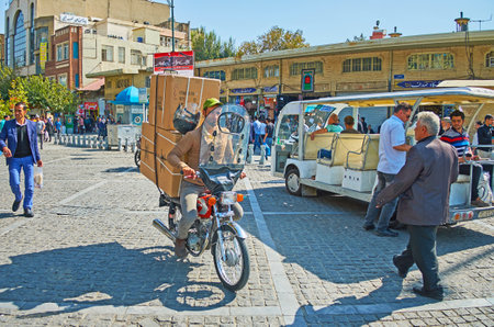 TEHRAN, IRAN - OCTOBER 11, 2017: The  Panzdah-e-Khordad street with chaotic traffic, crowded roadside, open air tourist bus and a bike, delivering big boxes to some store of Grand bazaar, on October 11 in Tehran.のeditorial素材