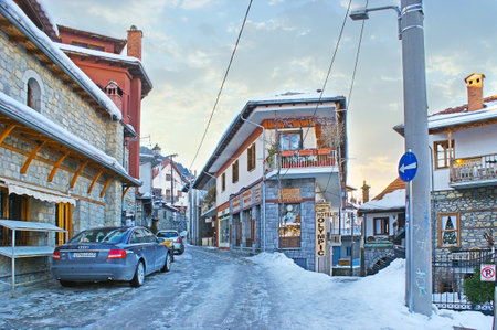 METSOVO, GREECE - JANUARY 2, 2012: The winding street of old town with traditional houses of Epirus region, multiple stores and hotels, on January 2 in Metsovo.のeditorial素材