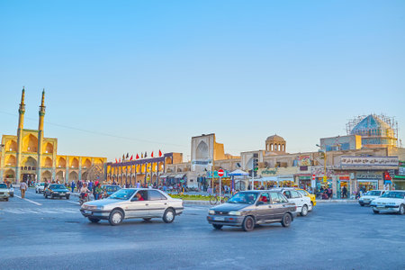 YAZD, IRAN - OCTOBER 17, 2017: The traffic on Imam Khomeini street with high minarets of  Amir Chakhmaq complex on the background, on October 17 in Yazdのeditorial素材