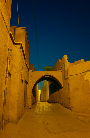 Beautiful view on narrow lane of old town in Yazd with mud-brick buildings and wind towers, Iranの写真素材