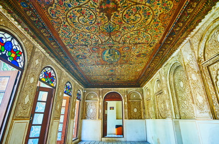 SHIRAZ, IRAN - OCTOBER 12, 2017: Preserved interior of Zinat Ol-Molk mansion with wooden ceiling, decorated with floral patterns and walls with reliefs of carved plaster, on October 12 in Shiraz.のeditorial素材