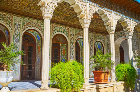 SHIRAZ, IRAN - OCTOBER 12, 2017: The shady gallery in Zinat Ol-Molk mansion decorated with carved plaster patterns and slender pillars, on October 12 in Shiraz.のeditorial素材