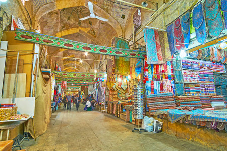 SHIRAZ, IRAN - OCTOBER 12, 2017: The wide alley of Vakil Bazaar with different stalls, offering wide range of local goods - fabrics, tapestry tablecloths, pillowcases, spices, accesorries and others, on October 12 in Shiraz.のeditorial素材