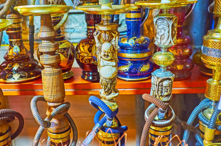 The shisha water pipes are decorated with carved ivory, depicting Buddha and antique portraits, the market stall in Shiraz, Iran.のeditorial素材