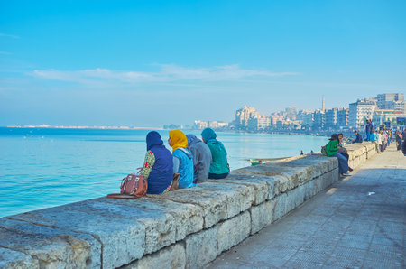 ALEXANDRIA, EGYPT - DECEMBER 17, 2017: The coast in city center is the popular place of rest and time spending among the locals, young people often come here to enjoy the seascape with friends, on December 17 in Alexandria.のeditorial素材