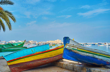 Pedestrian promenade along the Eastern harbor is occupied with many wooden boats of local fishermen,...